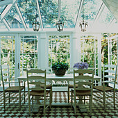 Conservatory with white painted Shaker style dining table and chairs