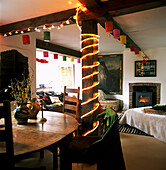 Fairy lights and paper lanterns adorn country cottage living room and dining area