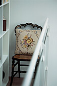 Vintage-Esszimmerstuhl mit Gobelin-Kissenbezug auf einem modernen Zwischengeschoss