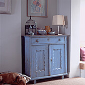 Still life of objects on salvaged blue painted wooden cabinet in living room