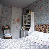 Blue and white bedroom with William Morris style wallpaper and off-white dresser