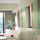 Moderne Wohnküche mit speziell angefertigter Lederbank und kühn gestreiften Wänden