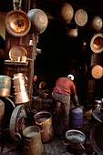 Copper metalworker in his shop in the old medina in Fez Morocco