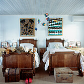 Kinderzimmer mit Mahagoni-Einzelbetten, die mit Kuscheltieren und einem Fisch-Mobile bestückt sind