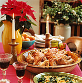 Gedeckter Weihnachtstisch mit einem Festmahl aus gebratenem Perlhuhn mit Austernpilzen Serrano-Schinken und Fino Sherry Kichererbsen und Spinat