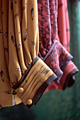 Detail of women's shirt sleeves hanging on a rail