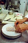 Chief putting slices of mushroom on plate