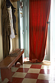 Concrete floors have been covered in bright Lino checkerboard tiles for warmth and a cheery entrance to the house 