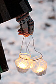 Holding a pair of glass tealight holders with gloves