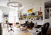 Modern Living room with shelves filled with artworks and arched windows and perspex light fitting
