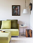 Lindgrünes Sofa und Kissen mit Kunstwerken in einem modernen Haus in London, England, UK