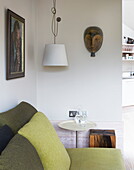 Lime green sofa and cushions with artwork in contemporary London home, England, UK