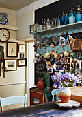 Küchenutensilien mit Kunstwerken, Fotos und Schnittblumen in einem Haus in Evershot, Dorset, Kent, Großbritannien