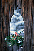 Verschneite Landschaft durch Holztür mit Weihnachtskranz in den Dolomiten