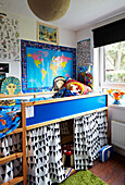 Hellblaues Plattformbett mit Wandkarte im Kinderzimmer eines Hauses in Hackney, East London, UK