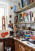 Bücher und Kunstzubehör mit Staffelei in einem Atelier in Hackney, East London, UK