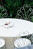 Altmodischer weißer Gartentisch mit Muscheln