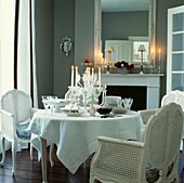 Cane chairs at dining table set with decanter and crystal candelabra