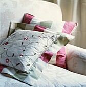 Floral and striped cushions on cream armchair