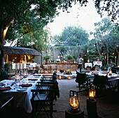 Outdoor dining area with set tables and catering grill at Singita in South Africa