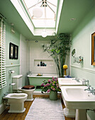 Oberlicht über einem elegant weiß gefliesten Badezimmer mit Papyruspflanze