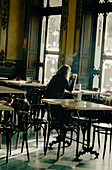 Frau sitzt an einem Tisch in einer eleganten Bar in Pamplona