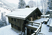 Wooden chalet in snow covered landscape