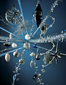 Close up of silvery Christmas decorations against blue background