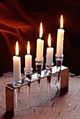 Lit candles in a glass and metal candle holder