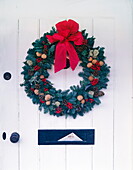 Christmas wreath on front door with red ribbon