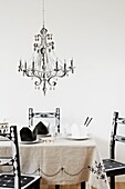 Personalised chairs at table with chandelier stencil on white wall