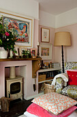 Armchair and woodburner with floor cushions in living room of contemporary Lewes home,  East Sussex,  England,  UK