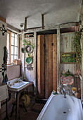 Small bathroom with wooden folding door in Benenden cottage,  Kent,  England,  UK
