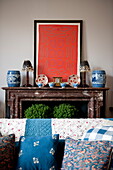 Sofa und Kunstwerk mit Ornamenten am Marmorkamin in einem Haus in Greenwich, London, England, UK