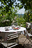 Teekanne und Tassen auf einer sonnenbeschienenen Terrasse in der Dordogne Frankreich