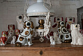 Collection of dog ornaments with pendant light on wooden sideboard  in Dorset home  Kent  UK