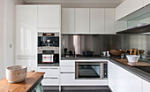 Große Schüssel auf Holztisch in Edelstahl und weißer Einbauküche in South Kensington Stadthaus London UK