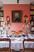 Esstisch mit Bücherregal und Glaskandelabern in einem Londoner Haus in England UK