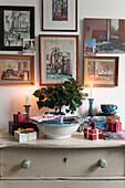 Framed artwork and lit candles with gift-wrapped presents in London home  England  UK