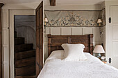 Bestickter Stoff über einem geschnitzten antiken Bett in einem Haus in Suffolk England UK