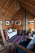 Woodburning stove and sofa in wooden summerhouse of Grade II listed cottage  Kent