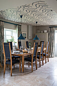 Tisch für acht Personen mit tapezierter Decke in einer umgebauten Scheune in Oxfordshire, England, Vereinigtes Königreich