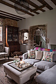 Corner sofa with view through arched doorway in Grade II Listed priory  Headcorn  Kent  UK