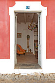 Blick durch die Tür von der rot gestrichenen Fassade in Castro Marim, Portugal