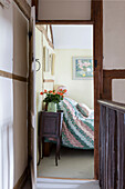 Rosen auf Nachttisch durch die Schlafzimmertür gesehen in Amberley cottage West Sussex UK