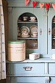 Cake tin and heart bunting on kitchen dresser in Amberley home West Sussex UK