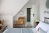 Wooden dressing table and chair with ensuite bathroom in attic bedroom of West Wittering home West Sussex England