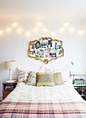 Gilt framed vintage mirror above double bed with tartan checked blanket in London family home,  England,  UK