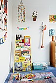 Bücherregal und Spielzeug im mit Teppich ausgelegten Kinderzimmer einer Londoner Familie, England, UK