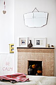 Tiled fireplace with vintage mirror in bedroom in London family home  England  UK